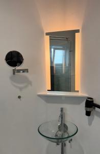 a bathroom with a sink and a mirror at Feldberg4you DesignZimmer in Feldberg