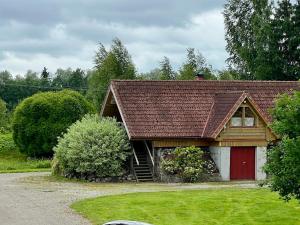 a house with a red door and a red garage at Countryhome apartment in Jõõpre