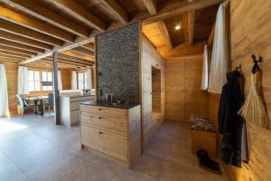 a kitchen with wooden walls and a counter in a room at Chalet Frümsel - Luxury & Bergblick in Wildhaus