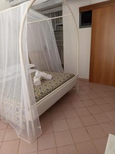 a bed with a canopy and a stuffed animal on it at Curtigghiu Room in Avola
