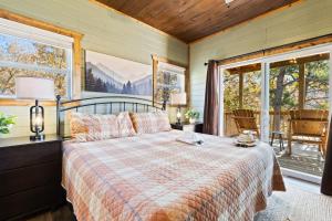 a bedroom with a bed in a room with windows at Luxe Mountain Pool Escape by Ghosal Luxury Lodging in Gatlinburg +138 photos