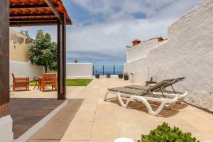 a patio with a table and chairs on a building at Casa Teide, disfruta de el atardecer en tu gran terraza privada in Icod de los Vinos