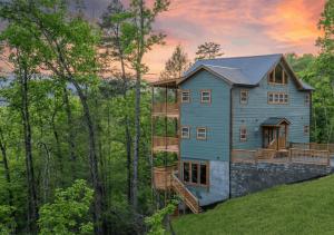 a house on top of a hill in the woods at Luxe Mountain Pool Escape by Ghosal Luxury Lodging in Gatlinburg