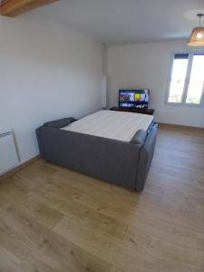 a large bed in a room with a wooden floor at Chez steph studio in Saint-Germain-Nuelles
