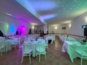a room with white tables and chairs and purple lights at Hotel Panorama in Cerreto di Spoleto