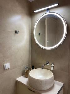 a bathroom with a sink with a large mirror at Folia City Center with Parking in Chalkida +1 photo