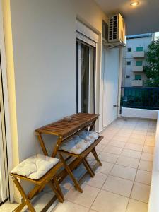 a wooden table and bench on a balcony at Folia City Center with Parking in Chalkida