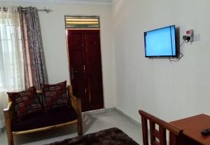 a living room with a chair and a television on a wall at Luanda Road View Hotel in Luanda