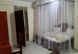 a bedroom with a bed and a window with curtains at Luanda Road View Hotel in Luanda +6 photos