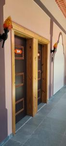 two wooden doors in a room with at Minakshi Resort in Loni Kand