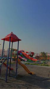 a playground with a slide in a park at Minakshi Resort in Loni Kand