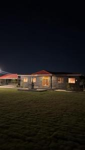 a building at night with a field in front of it at Minakshi Resort in Loni Kand