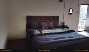 a bedroom with a large bed with a large headboard at Doma Hotel lachung in Lachung