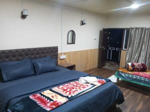 a bedroom with a bed with a blue comforter at Doma Hotel lachung in Lachung