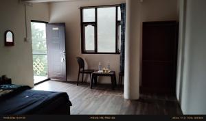 a bedroom with a table and a chair and a window at Doma Hotel lachung in Lachung