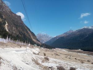 a view of a snowy mountain with mountains in the background at Doma Hotel lachung in Lachung