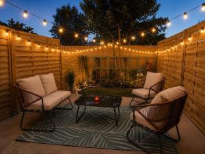 a patio with chairs and a table and lights at Le Nid des Wallabys in Monchy-le-Preux