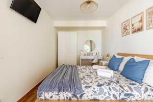 a bedroom with a bed with blue pillows at Casa Teide, disfruta de el atardecer en tu gran terraza privada in Icod de los Vinos