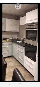 a kitchen with white cabinets and an oven at Fagernes sentrum 1 sleeping rom in Fagernes