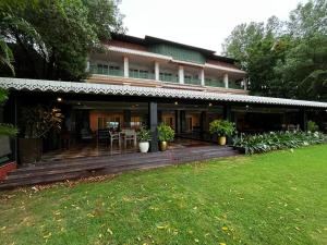 a house with a wooden porch with a lawn at MAYFAIR Lake Resort in Raipur