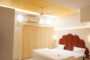 a bedroom with a bed with a red headboard at Hotel Maruti in Mandsaur