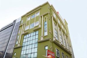 a green building with windows on the side of it at Hotel Maruti in Mandsaur