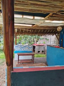 a bench sitting under a roof with a stove at Al Mar Bed and Breakfast in Watamu +19 photos