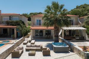 a villa with a palm tree and a swimming pool at Azura Villa #Skgbnb in Mesochórion