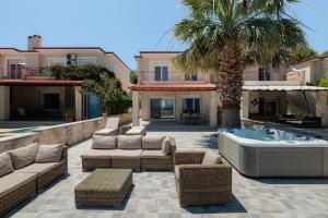 a patio with a hot tub and a palm tree at Azura Villa #Skgbnb in Mesochórion
