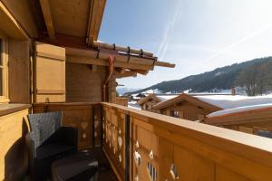 a balcony with a chair and a snow covered mountain at Chalet Frümsel - Luxury & Bergblick in Wildhaus