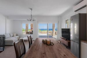 a living room with a wooden table and a television at Azura Villa #Skgbnb in Mesochórion