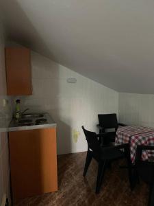 a small kitchen with a table and chairs and a stove at Villa Pistula apartments in Ulcinj +7 photos