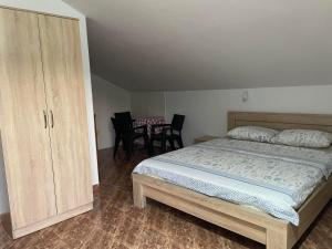 a bedroom with a bed and a cupboard and chairs at Villa Pistula apartments in Ulcinj