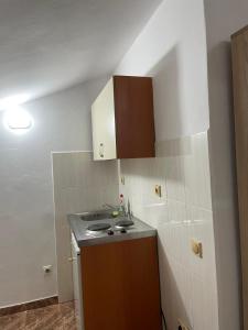 a small kitchen with a sink and a stove at Villa Pistula apartments in Ulcinj
