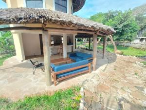 a gazebo with a thatched roof on a patio at Tiny house, kitchen downstairs in Shimoni +3 photos