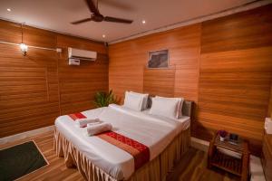a bedroom with a large bed with wooden walls at Giri Mandala The Mountain Vihar in Welhe +54 photos