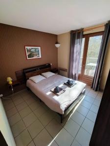 a bedroom with a large bed and a window at Auberge du Tarnon in Vébron