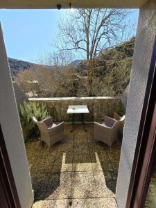 a patio with two chairs and a table on a balcony at Auberge du Tarnon in Vébron