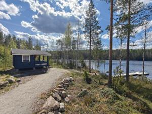 a tiny house on the shore of a lake at Lomamökki seitsemisen kansallispuiston lähellä in Aurekoski