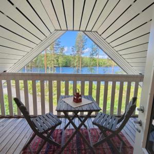 a table and chairs on a porch with a view of the water at Lomamökki seitsemisen kansallispuiston lähellä in Aurekoski
