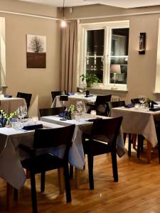 a dining room with white tables and black chairs at Maritim Hotell & Krog in Simrishamn