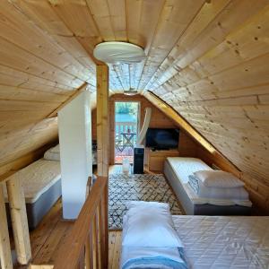a bedroom with two beds in a wooden cabin at Lomamökki seitsemisen kansallispuiston lähellä in Aurekoski