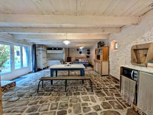 a living room with a table and a kitchen at La Grange avec Jacuzzi in Loguivy-Plougras