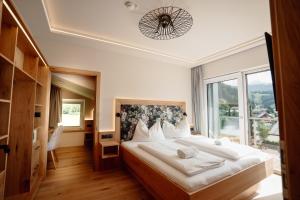 a bedroom with a large bed and a large window at Das Filzmoos in Filzmoos