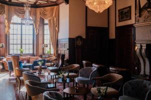 a waiting room with chairs and tables and a chandelier at Lejondals Slott in Bro