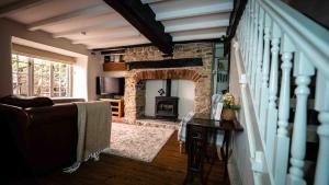 a living room with a stone fireplace and a couch at Freya's Cottage in Lincoln