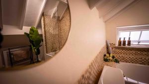 a bathroom with a mirror and a sink and a tub at Freya's Cottage in Lincoln +33 photos