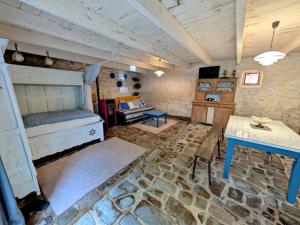 a bedroom with a bed and a table in a room at La Grange avec Jacuzzi in Loguivy-Plougras