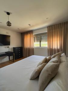 a bedroom with a large white bed with pillows at Santiurde Suites in Quintanilla de Arriba +38 photos