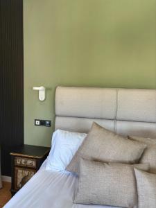 a bedroom with a bed and a side table with a lamp at Santiurde Suites in Quintanilla de Arriba